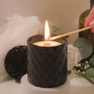 Black candle being lit with matchstick.