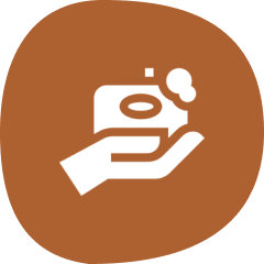 Hand holding a camera icon, brown background.