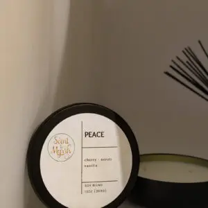 Candle labeled "Peace" with reed diffuser.
