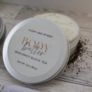 Body butter container on wooden surface.